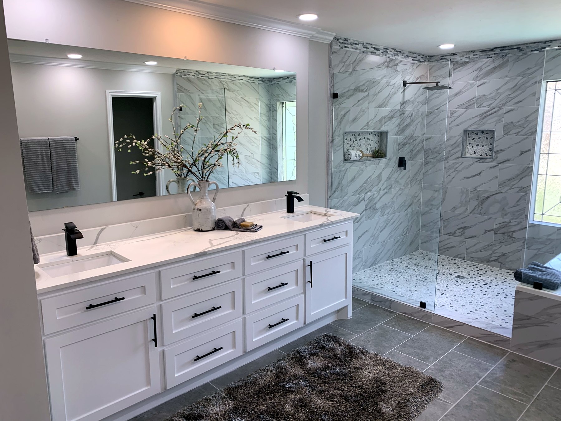 Complete Surface Doctors bathroom renovation with vanity, shower tile, and glass enclosure